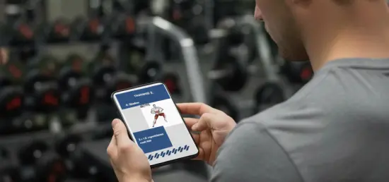 Focused on Training: Man in Gym Reviews "Skater" Exercise on Phone